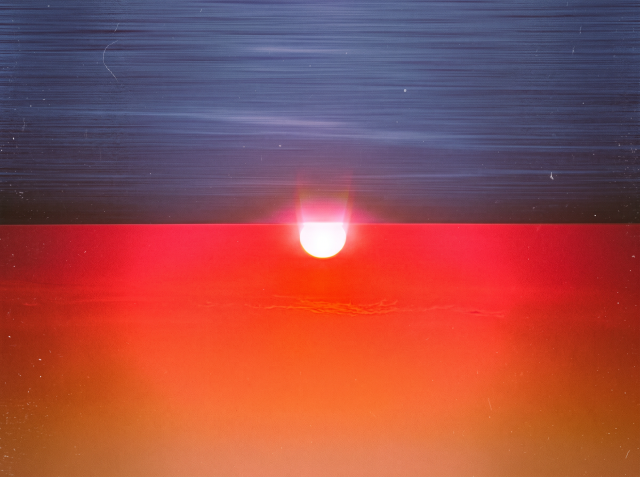 AI-generated image of a brilliant red and orange sunset reflected on water, with a glowing white sun at the horizon beneath a deep blue streaked sky.