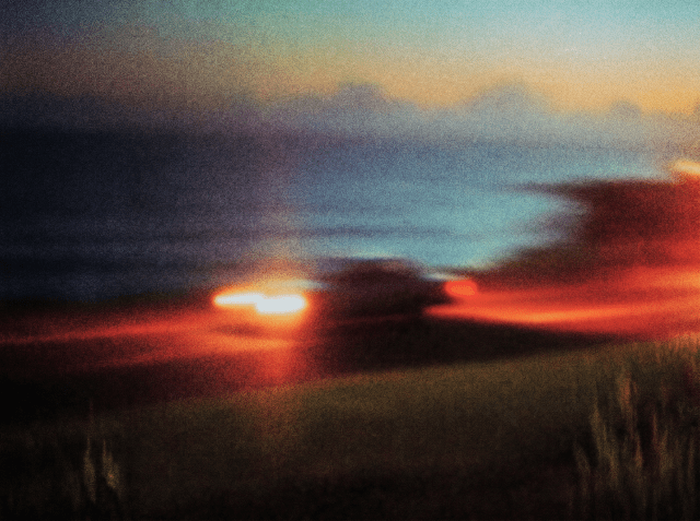Blurred, grainy sunset over a flat grassy field, with vivid red and orange clouds glowing against a teal sky.