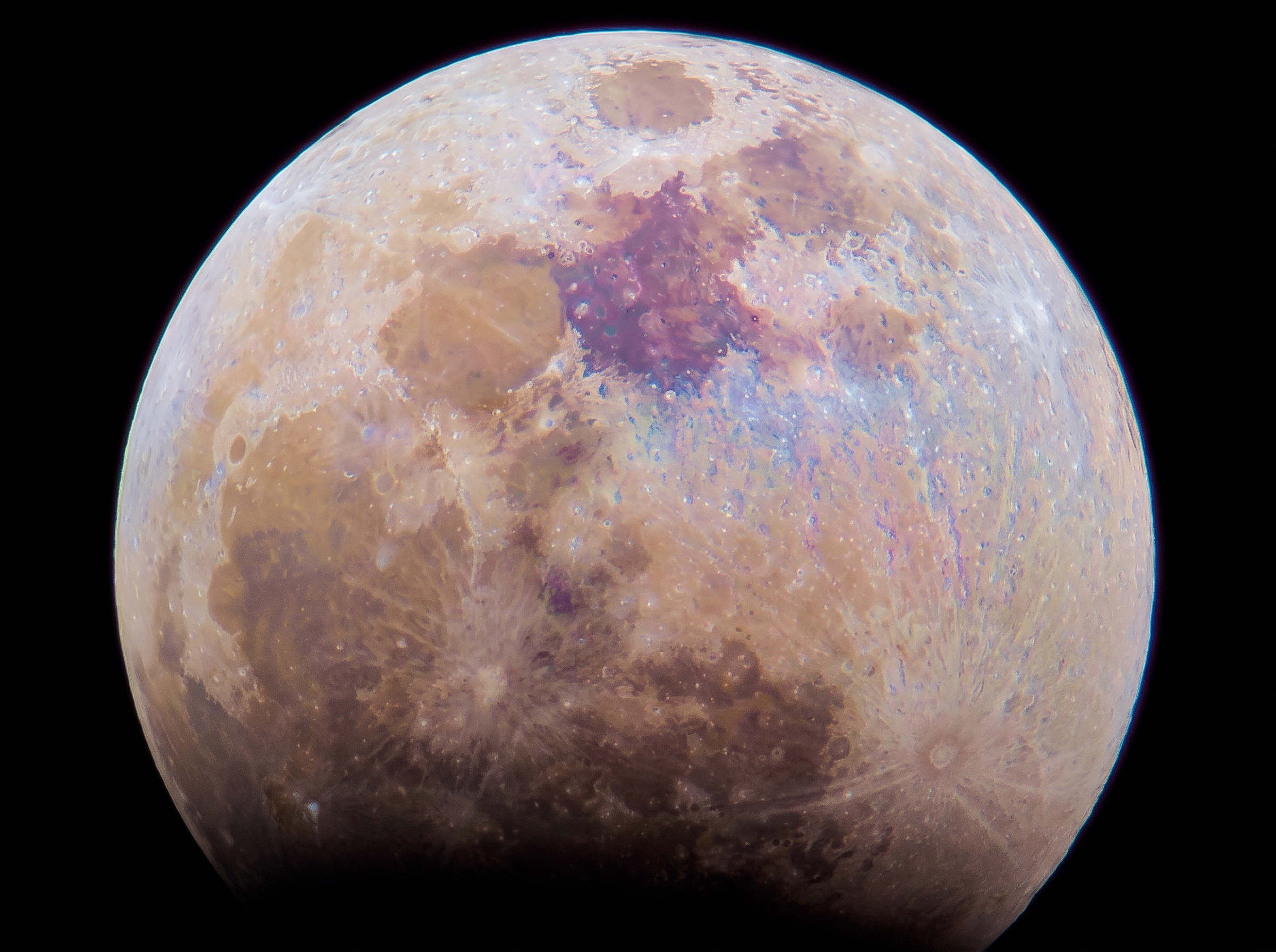 Color-enhanced full moon showing craters, ray systems, and dark lunar maria against a black background.